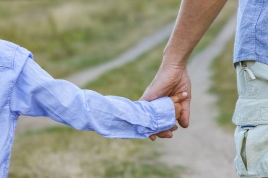 Mutlu çocuk ve ebeveynin parktaki gezinin doğasında elleri var.