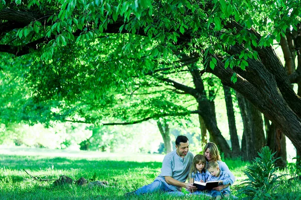 Счастливая Молодая Семья Читающая Библию Природе — стоковое фото