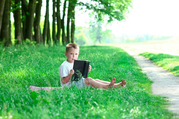 男孩在户外看书圣经 — 图库照片