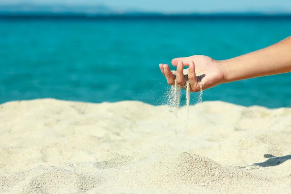 女性の手が海岸に砂を流し — ストック写真