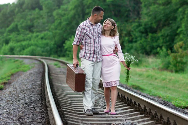 那对年轻夫妇带着手提箱在铁路上 — 图库照片
