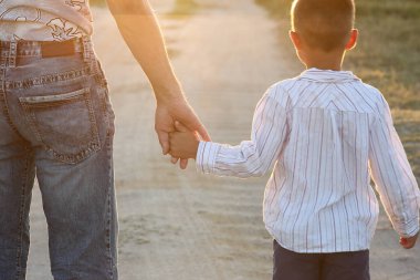 Ebeveyn küçük bir çocuğun elini tutar.