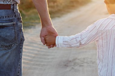 Ebeveyn küçük bir çocuğun elini tutar.