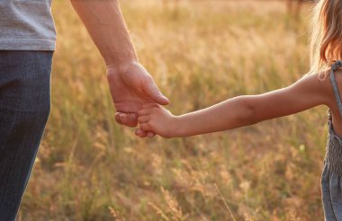 Ebeveyn küçük bir çocuğun elini tutar.