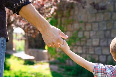 Ebeveyn küçük bir çocuğun elini tutup yürür.