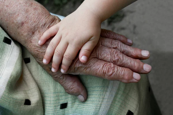 Mormors Gamla Hand Håller Ett Litet Handbarn — Stockfoto