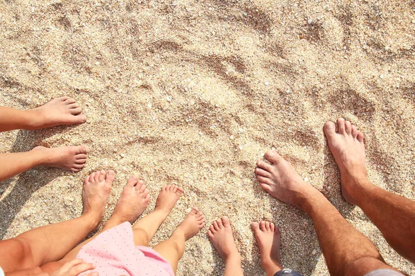 海の背景の近くの砂の上の美しい家族全員の足 — ストック写真