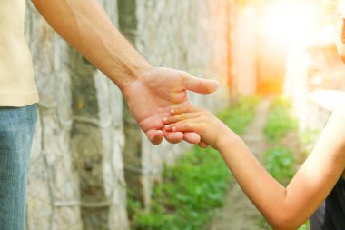 Ebeveyn küçük bir çocuğun elini tutar.