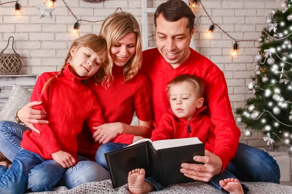 幸せな家族はクリスマスに家で本を読んで — ストック写真