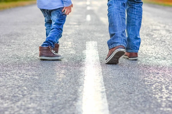 自然旅行で公園内の道路上の親と子供の美しい足 — ストック写真