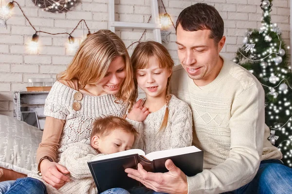 幸せな家族はクリスマスに家で本を読んで — ストック写真