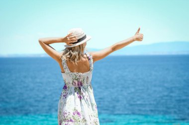 Hafta sonu doğa gezisinde deniz kıyısında mutlu bir kız.