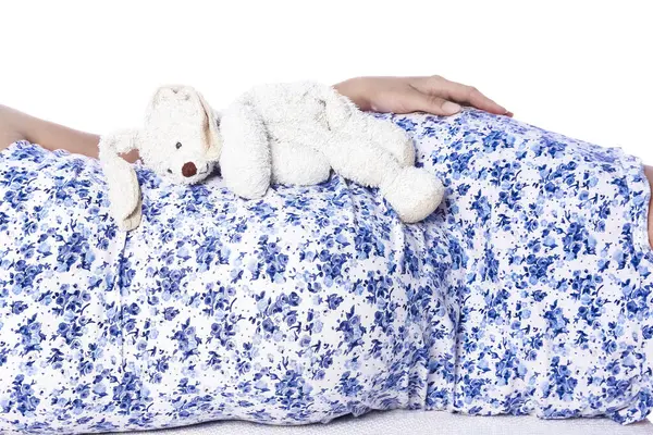 Mutlu hamile kız beyaz arka planda yatıyor.