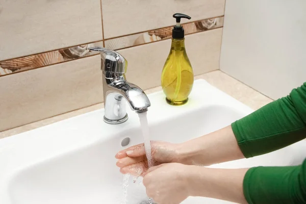 Hands with soap are washed under the tap with water. Clean from infection and dirt and virus. At home or in the hospital ablution office.