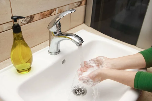 Hands with soap are washed under the tap with water. Clean from infection and dirt and virus. At home or in the hospital ablution office.