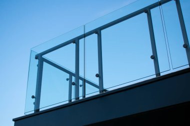 Temperli cam balkon korkulukları. Gökyüzü mavisi arka plan.