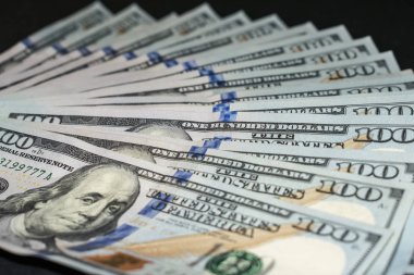 Siyah bir arka plan üzerinde yüz dolarlık banknotlar 