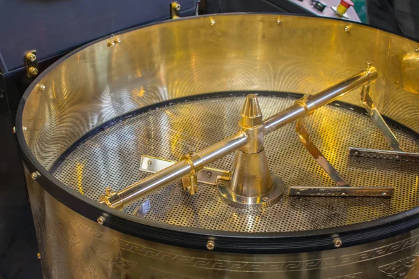 Golden empty cooling tray of a coffee roaster.