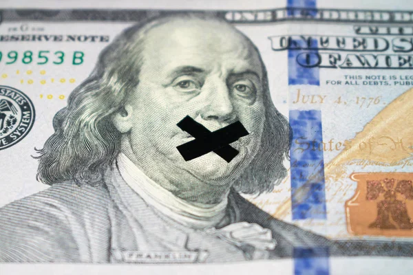 Taped mouth of Benjamin Franklin on a banknote