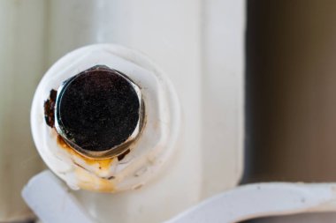 Sızıntı noktası. Merkezi ısıtma radyatörünün alt tıkacı. Çerçevede oksitlenme.