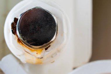 Sızıntı noktası. Merkezi ısıtma radyatörünün alt tıkacı. Çerçevede oksitlenme.