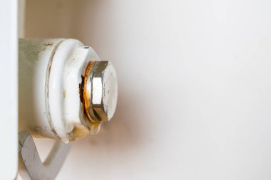 Merkezi ısıtma kaloriferinin paslı tıpası. Sızıntı noktası. Fişin altındaki su damlası.