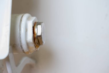 Merkezi ısıtma kaloriferinin paslı tıpası. Sızıntı noktası. Fişin altındaki su damlası.