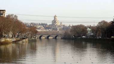 Georgia, Tiflis - Ocak 2018: Kura Nehri üzerinde köprü görünümünden Katedrali.