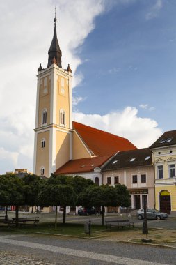 Rimavska Sobota, Slovakya - 14 Ağustos 2018: Kilise ve tarihi kasaba evleri içinde Ana Meydanı, Rimavska Sobota, Slovakya