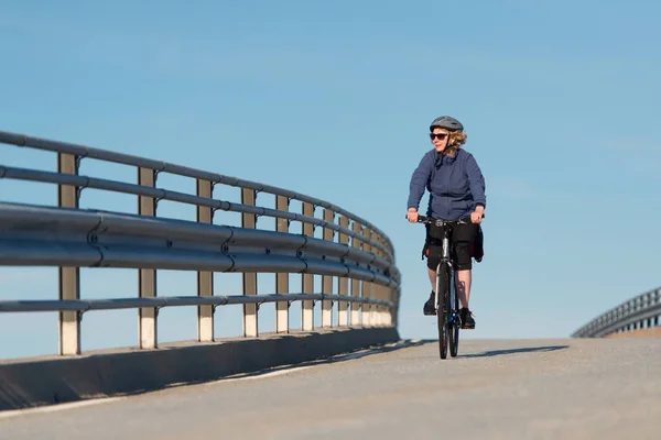 骑自行车穿过桥的女人 — 图库照片