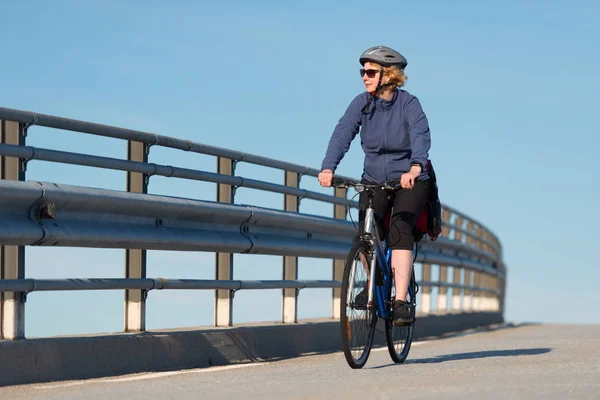 骑自行车穿过桥的女人 — 图库照片