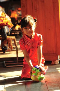 Tayland, Pattaya - 29 Ocak 2009: Küçük Tay kız oyuncakla kırmızı elbiseli