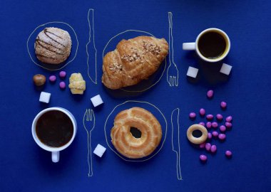 İki kahve kupaları pişmiş tatlılar, şekerler üzerinde arka plan mavi.