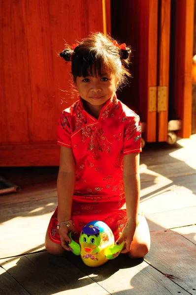 Tayland, Pattaya - 29 Ocak 2009: Küçük Tay kız oyuncakla kırmızı elbiseli