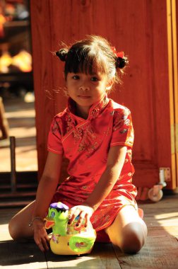 Tayland, Pattaya - 29 Ocak 2009: Küçük Tay kız oyuncakla kırmızı elbiseli