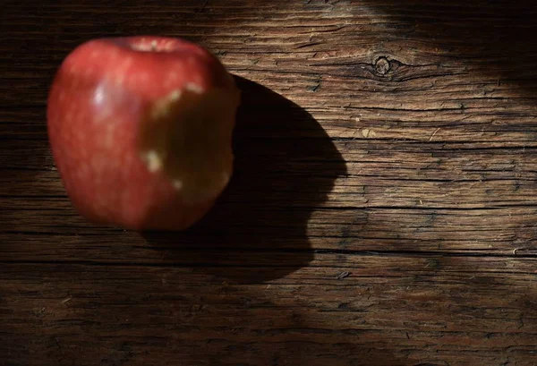 Roter Apfel Mit Einem Loch Das Auf Einer Braunen Holzoberfläche — Stockfoto