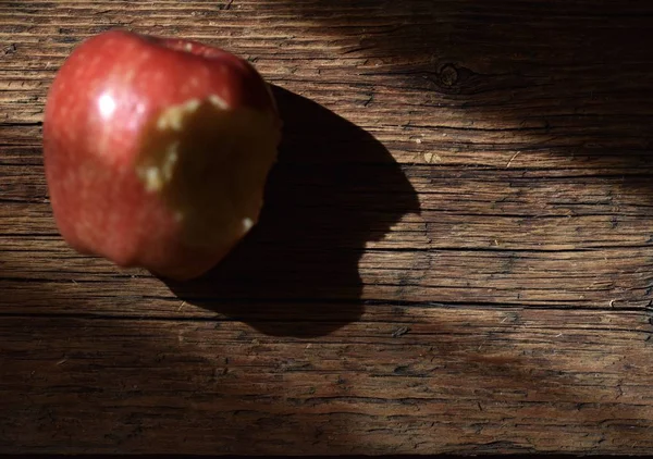 Roter Apfel Mit Einem Loch Das Auf Einer Braunen Holzoberfläche — Stockfoto