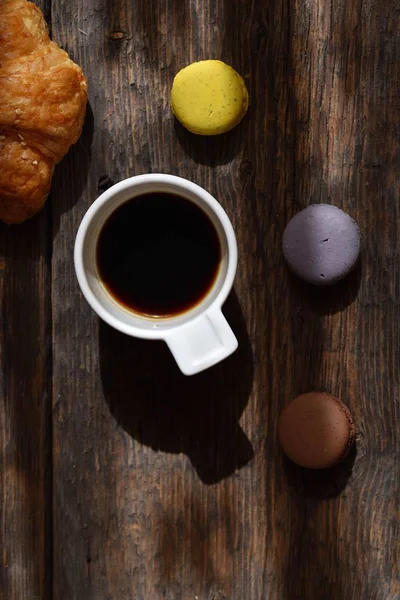 Coffee mood on rustic wooden table, croissant and coffee