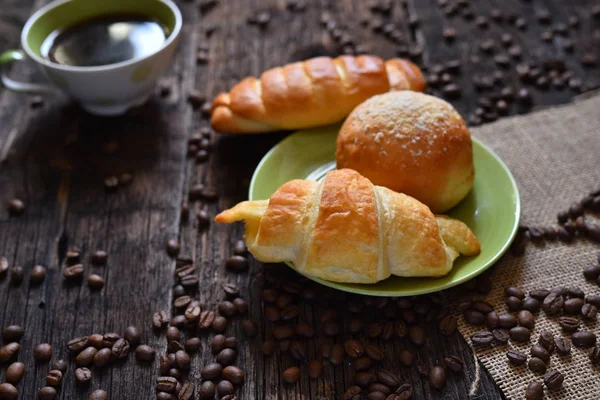 Coffee mood on rustic wooden table, croissant and coffee