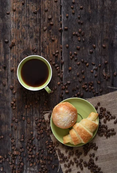 Coffee mood on rustic wooden table, croissant and coffee