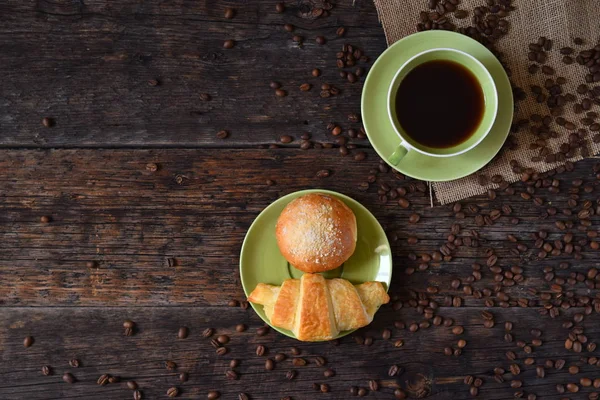 Coffee mood on rustic wooden table, croissant and coffee