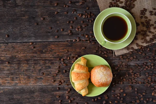 Coffee mood on rustic wooden table, croissant and coffee