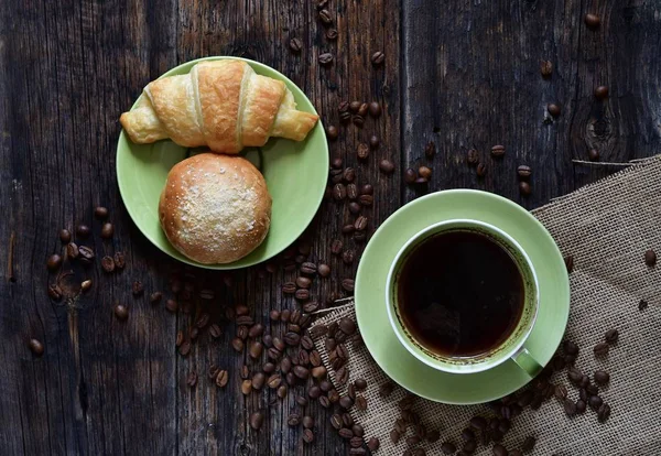 Coffee mood on rustic wooden table, croissant and coffee