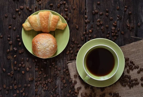 Coffee mood on rustic wooden table, croissant and coffee