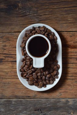 Kahve, kahve çekirdekleri ahşap arka plan üzerinde beyaz Kupası 