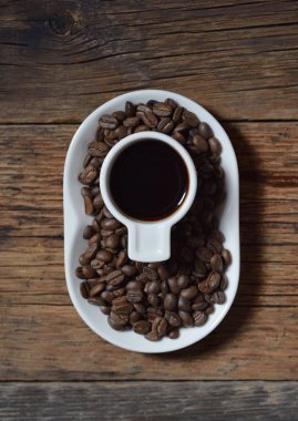 Kahve, kahve çekirdekleri ahşap arka plan üzerinde beyaz Kupası 