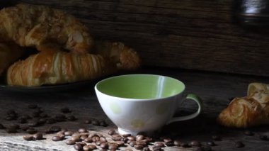 Bir fincan aromalı kahve ile eski bir ahşap masa arka plan üzerinde ay çöreği. Görüntü 4 k. Kahve ruh hali 