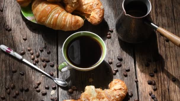 Kávé összetétele. Csésze kávé, croissant, kávé bab és réz kávéfőző régi fából készült asztal háttere. 4 K kép 