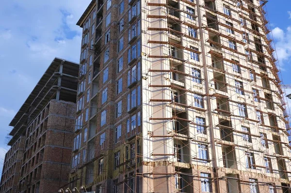 The construction phase of the building facade. Scaffolding for finishing works of external walls of the building.