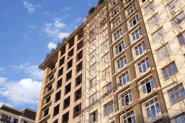 The construction phase of the building facade. Scaffolding for finishing works of external walls of the building.